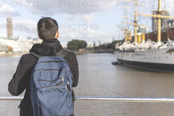 Back view of a tourist posing in front of a boat in Puerto Madero