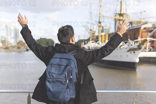 Back view of a tourist posing in front of a boat in Puerto Madero