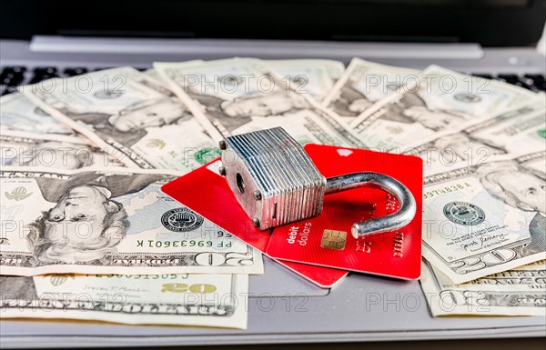 Close up of Padlock on top of credit card on dollar bills