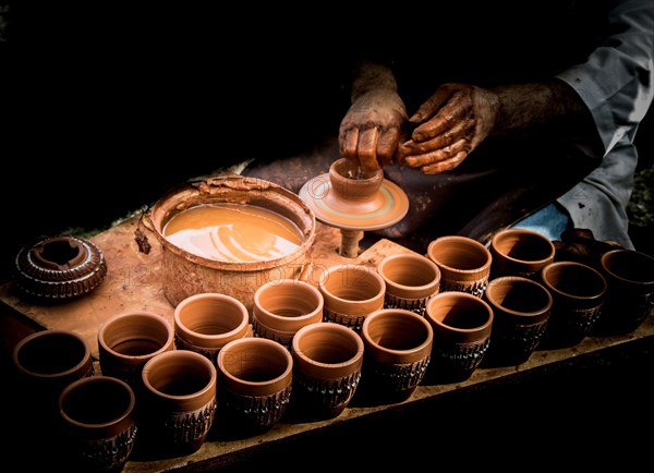 Potter`s hands shaping up the clay of the pot