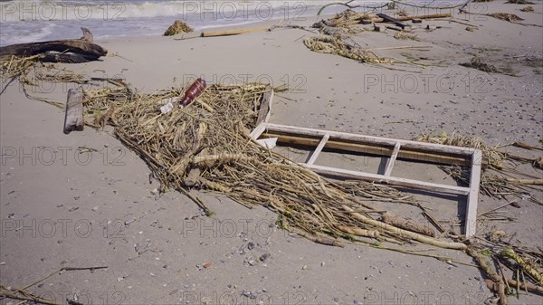 Window frame of house lies on sand