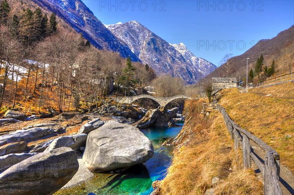 Roman Bridge Ponte dei Salti over a River with Snow-capped Mountain in Valley Verzasca in Ticino