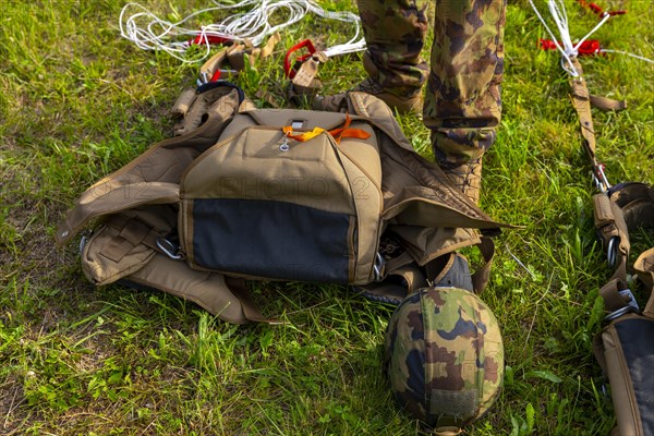 Military Parachuter Standing on the Grass with His Parachute in Switzerland