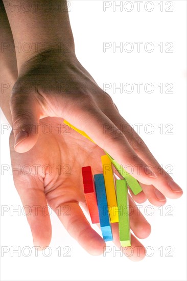 Falling colorful domino off hand on white background