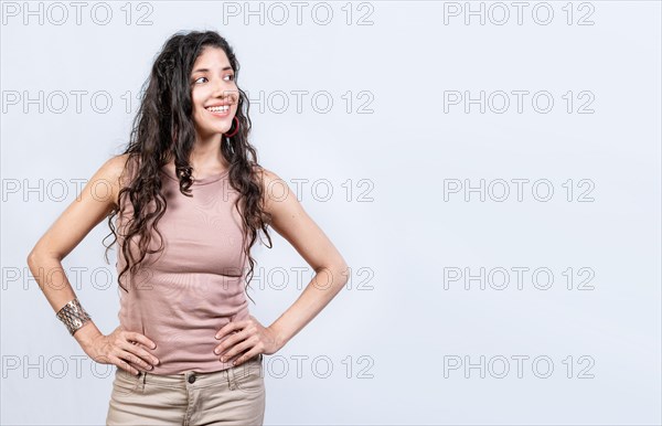 Thoughtful smiling girl looking at a blank space. Young woman looking at an advertisement to the side