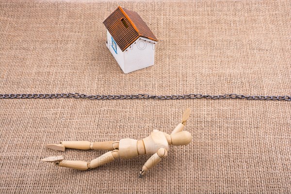Man figurine and a Model house beyond the chain line on a canvas