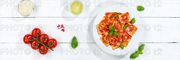 Ravioli Italian pasta eat lunch dish with plate in tomato sauce from above on wooden board Panorama in Stuttgart