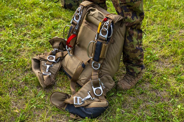 Military Parachuter Standing on the Grass with His Parachute in Switzerland