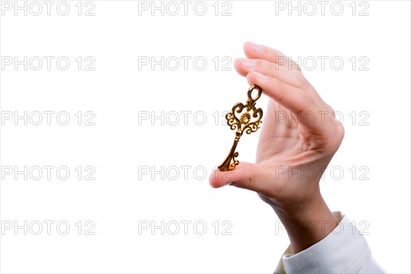 Hand holding a retro styled metal key on a white background