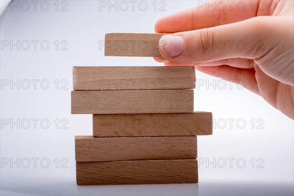 Hand holding wooden domino on a white background