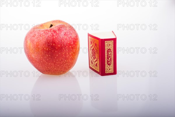 Red apple and Islamic Holy Book Quran in mini size