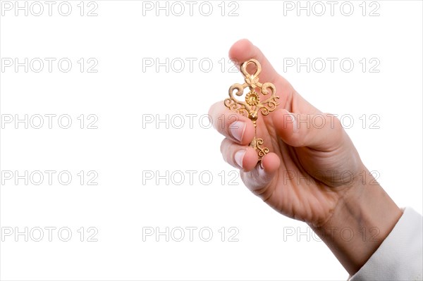 Hand holding a retro styled metal key on a white background