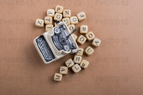 Letter cubes of made of wood around model typewritter