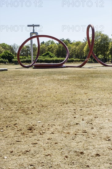 Withered meadow and sculpture of a water tap