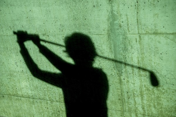Shadow of a Golfer on a Wall Holding a Golf Club
