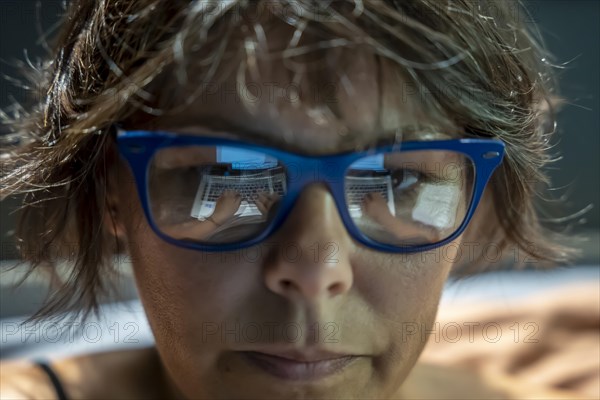 Beautiful Business Woman Face with Eyeglasses Reflection When She is Working on Her Laptop in Switzerland