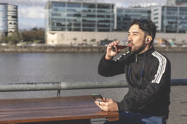 Latin tourist drinking beer at an outdoor bar in Puerto Madero