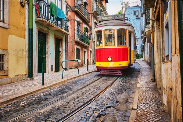 Famous vintage yellow tram 28 in the narrow streets of Alfama district in Lisbon