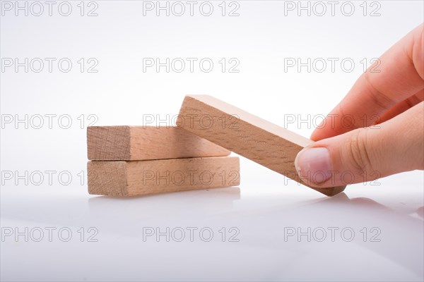 Hand holding wooden domino on a white background