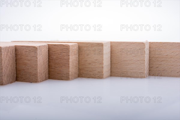 Wooden Domino Blocks in a line on a white background