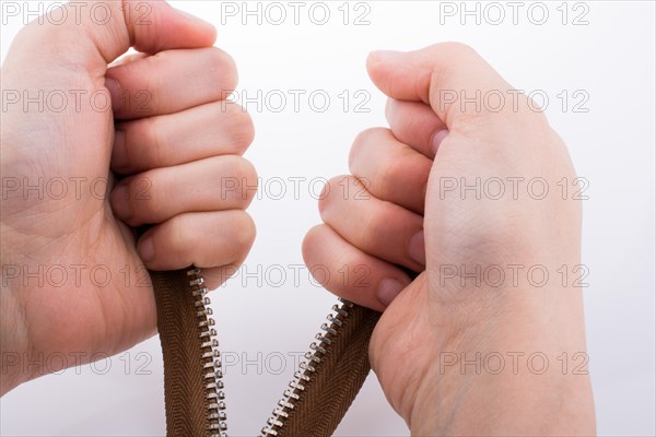 Hand holding color zipper on a white background