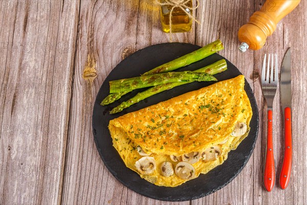 Mushroom omelette with wild asparagus on a slate