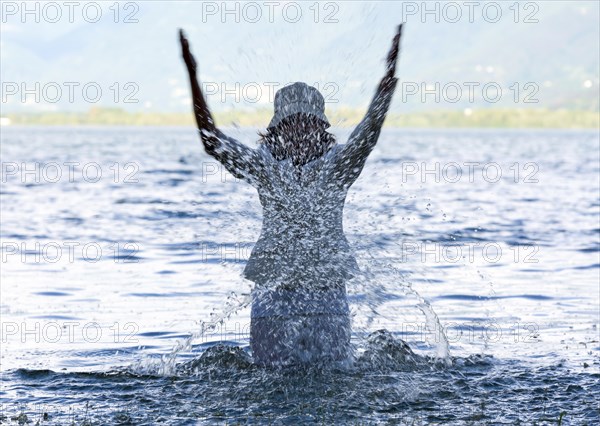 Woman Standing in a Flooding Alpine Lake with Snow-capped Mountain in Locarno