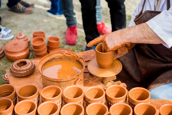 Potter`s hands shaping up the clay of the pot