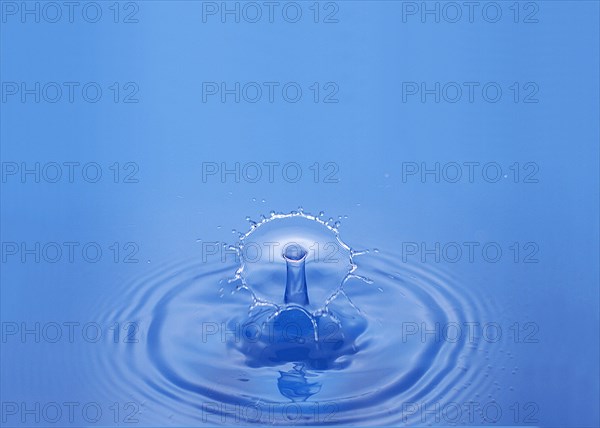 Drop of Water falling against Bleu background