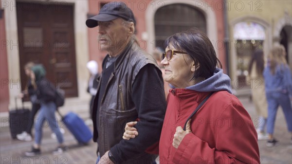 Elderly couple of tourists are walking through the historical center seeing the sights in an old European city. Palace Square