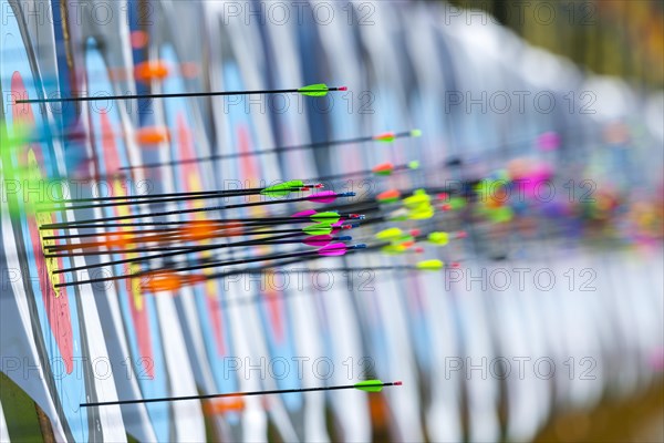 Lots of colourful arrows stuck in targets in archery