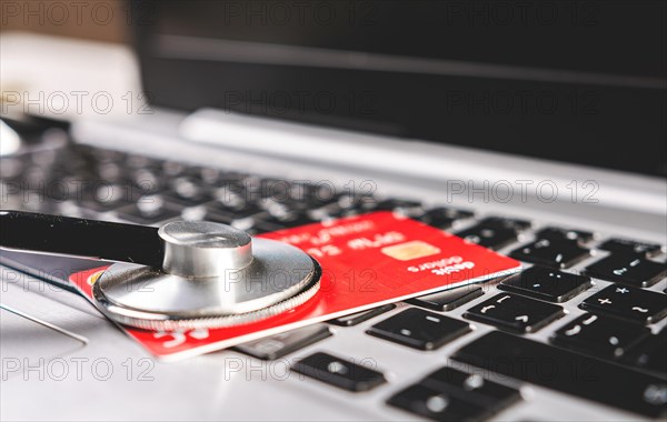 Stethoscope and credit card on the keyboard. Medical healthcare cost concept