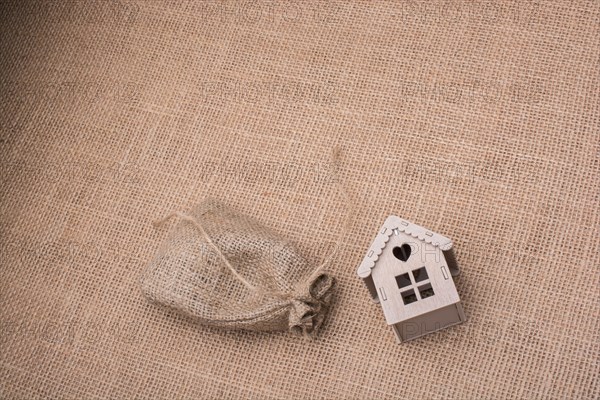 Model house beside a sack on a canvas background