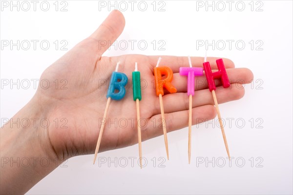 Color candles in hand on sticks write the word birth
