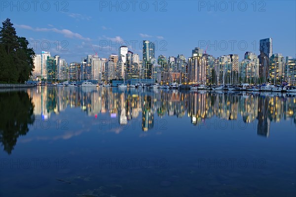 Illuminated skyscrapers reflected in calm water