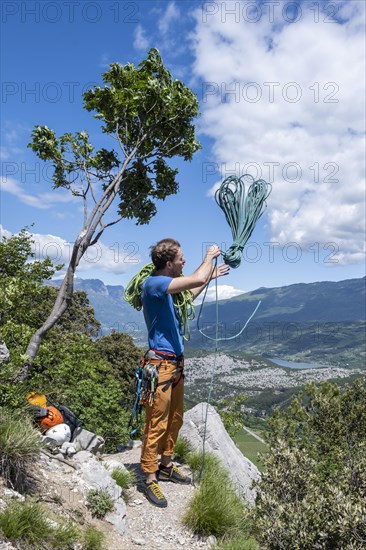 Climber throws climbing rope over his shoulder