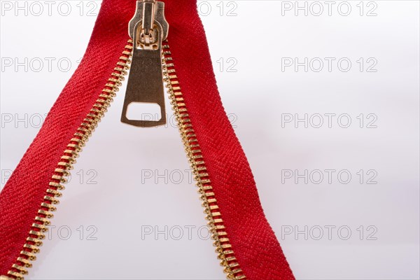 Hand holding color zipper on a white background