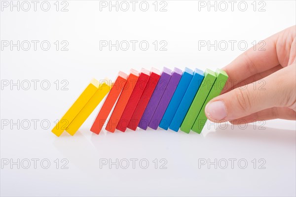 Hand holding color dominoes on a white background