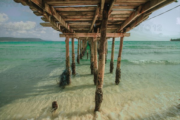 View of the waves and sea under a wooden boardwalk in Koh Rong Samloen in Cambodia