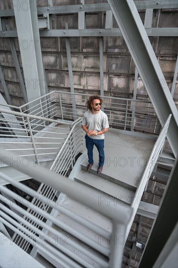 Young man with afro hair on the stairs in the city