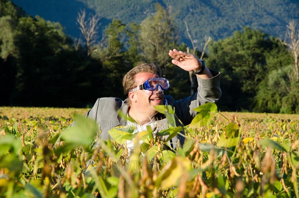 Happy and Elegant Business Man in the Bean Field with Arm Raised and Diving Mask