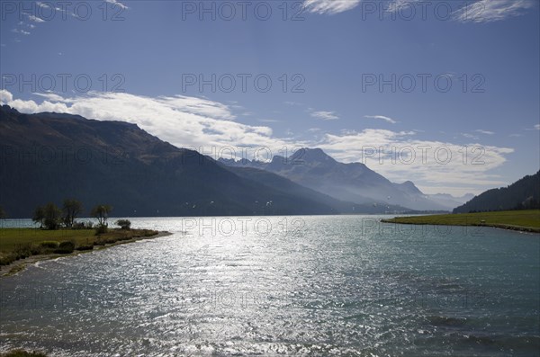 Kite Surfer on a Lake Silvaplana with Mountain and Blue Sky with Clouds in Switzerland