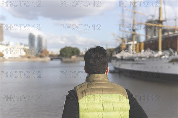 Back view of a tourist posing in front of a boat in Puerto Madero
