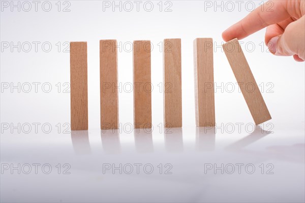 Hand holding wooden domino on a white background