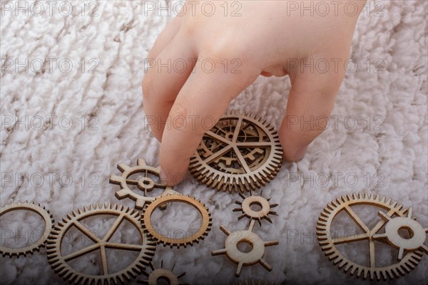 Hand holding gear wheels as the concept of mechanism