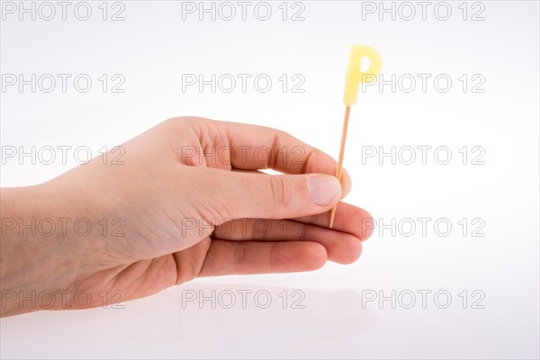 Color candle in hand on sticks writes the letter P