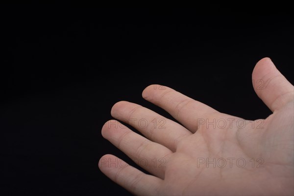 Five fingers of a child hand partly seen in black background