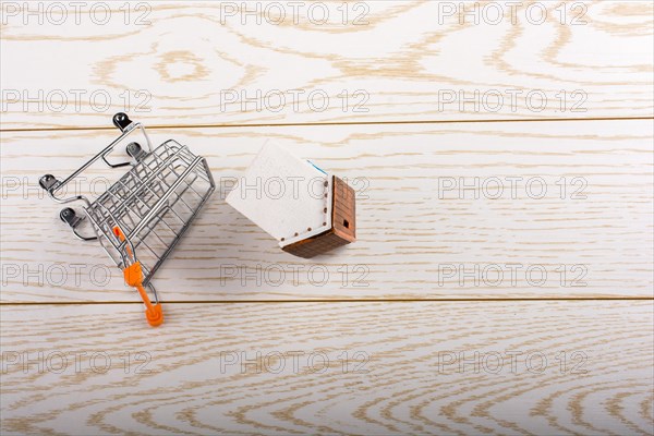 Little model house and a trolley and on a parquet background