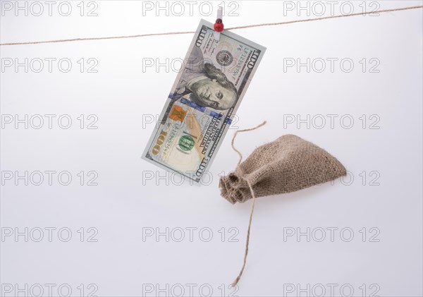 Banknote of US dollar hanging on a linen string