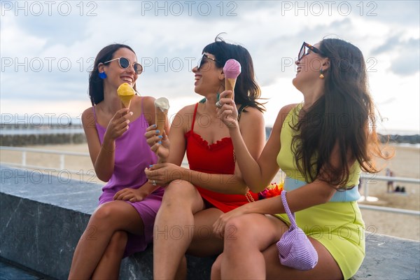 Young female friends eating ice cream on summer vacation